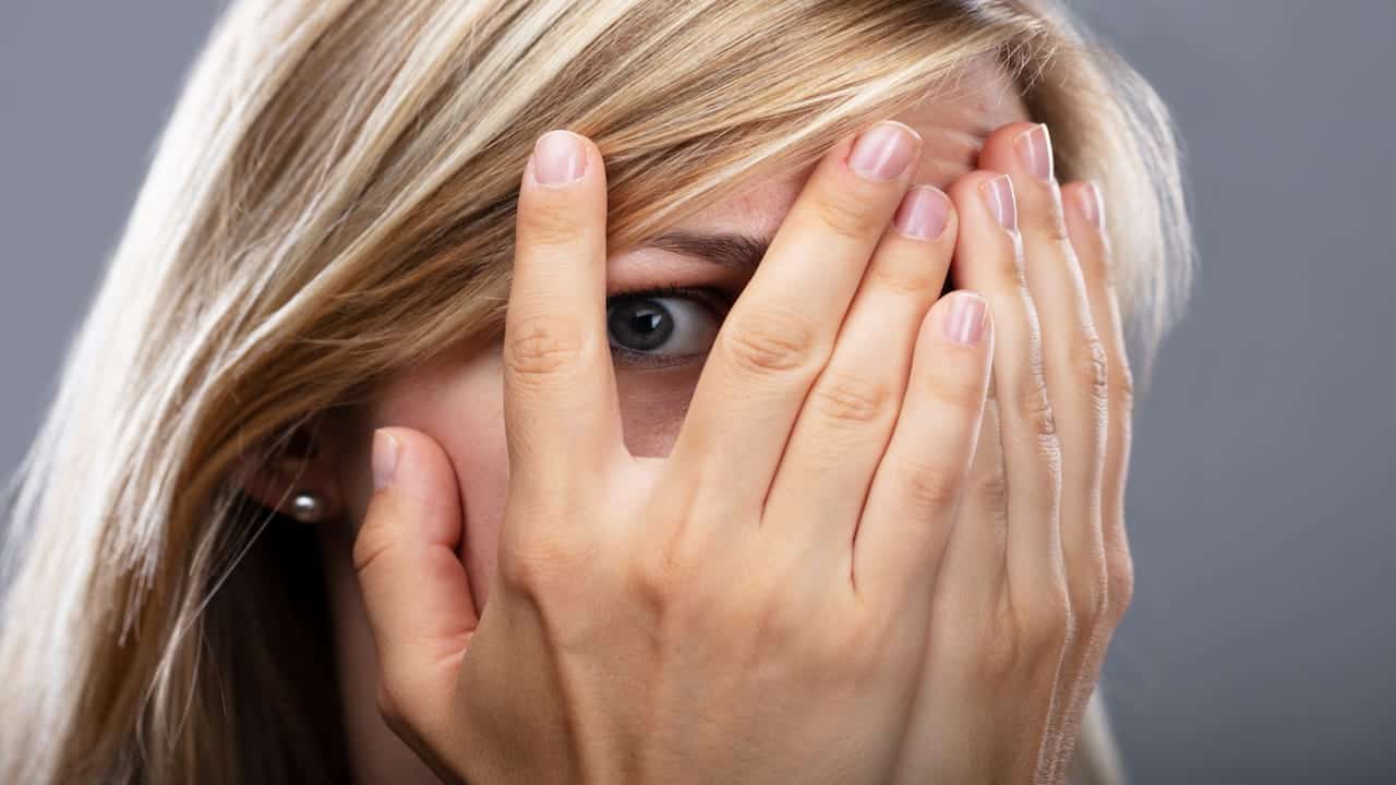 A Scared Woman Peeking Through Fingers