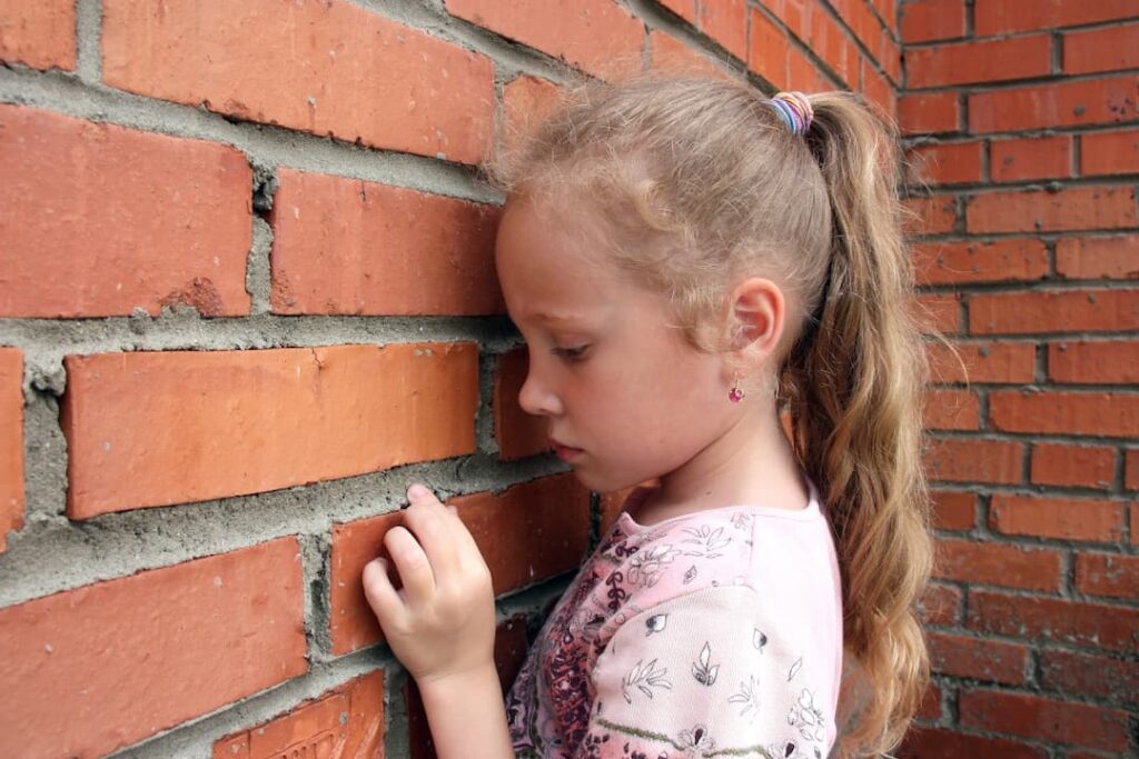 sad girl leaning against the brick wall