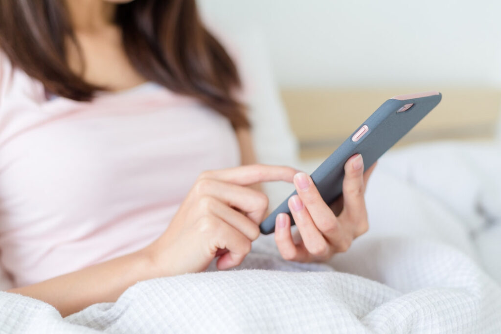 a woman in bed using her cellphone