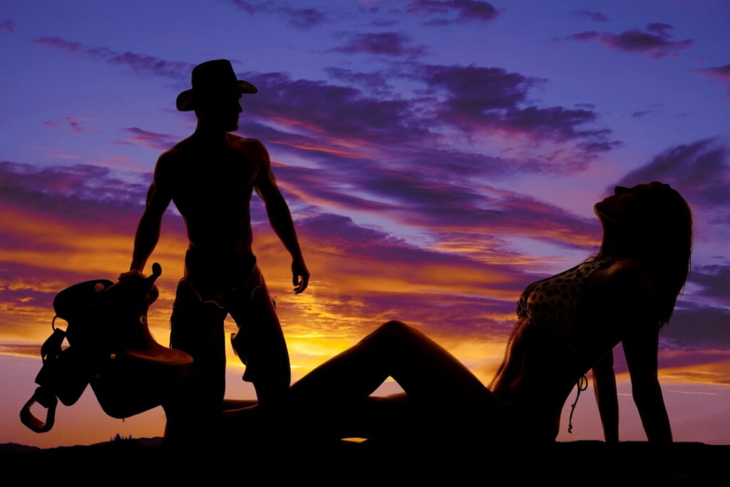 silhouettes of a cowboy and a woman on the sunset