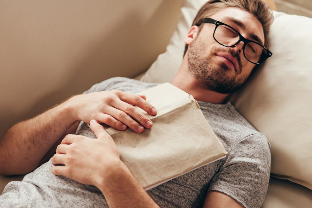 a man sleeping with a book on his chests 