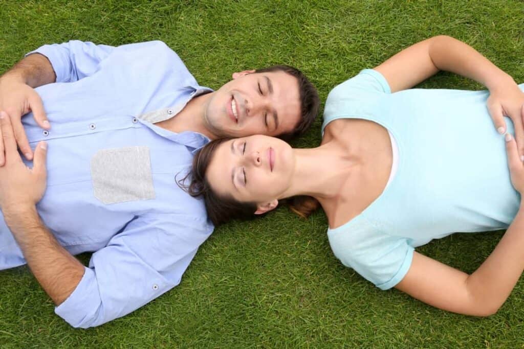 a happy couple lying on the grass