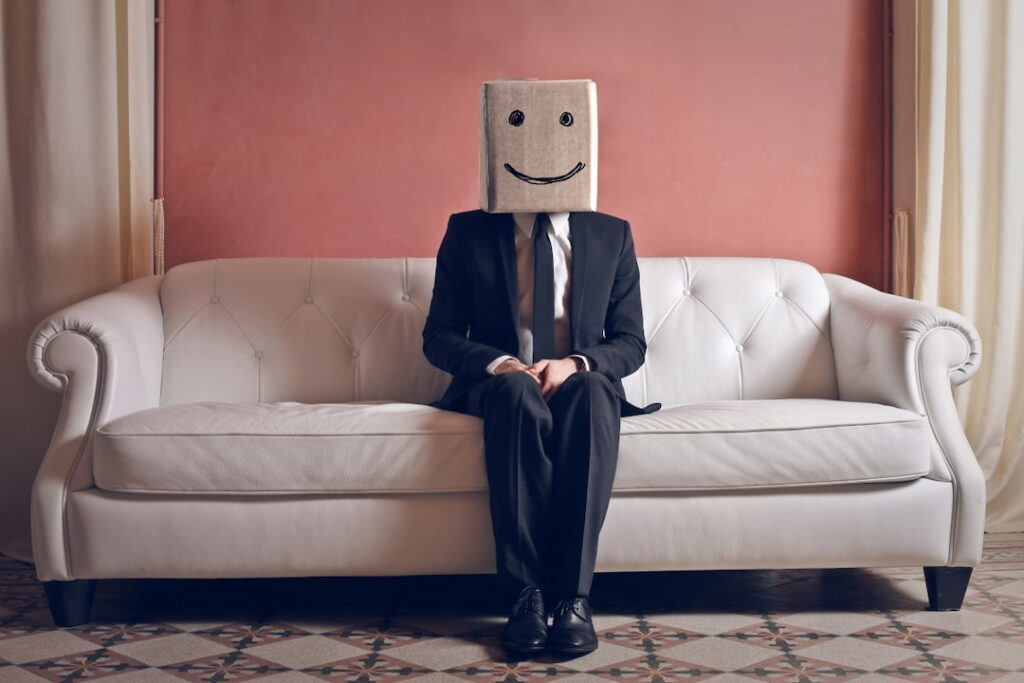 a man sitting on the couch with a box over his head