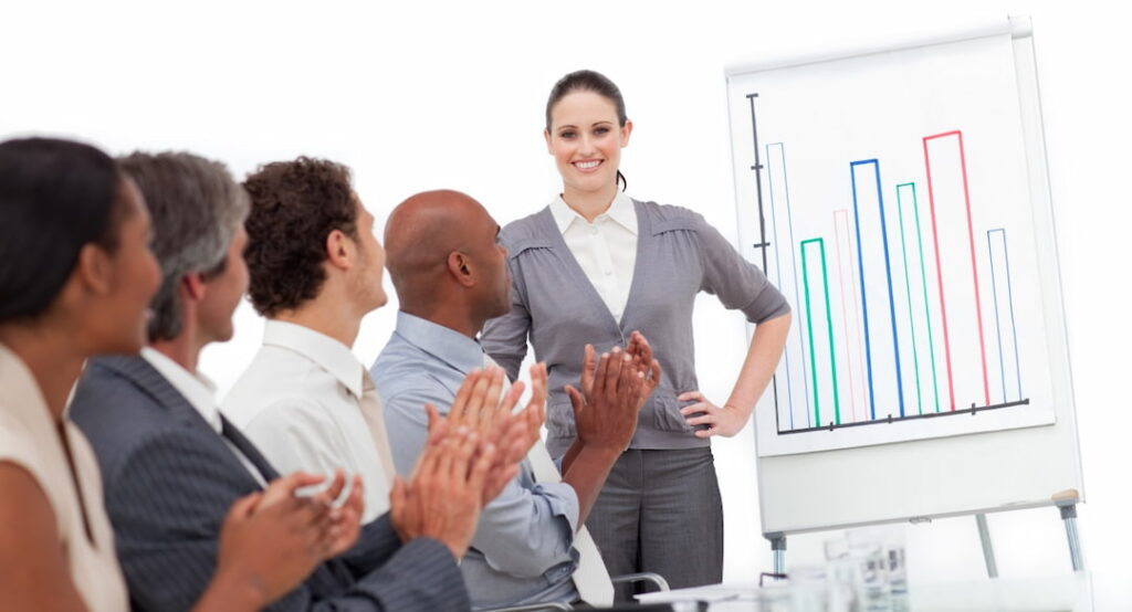 A team applauding to a woman after the presentation 