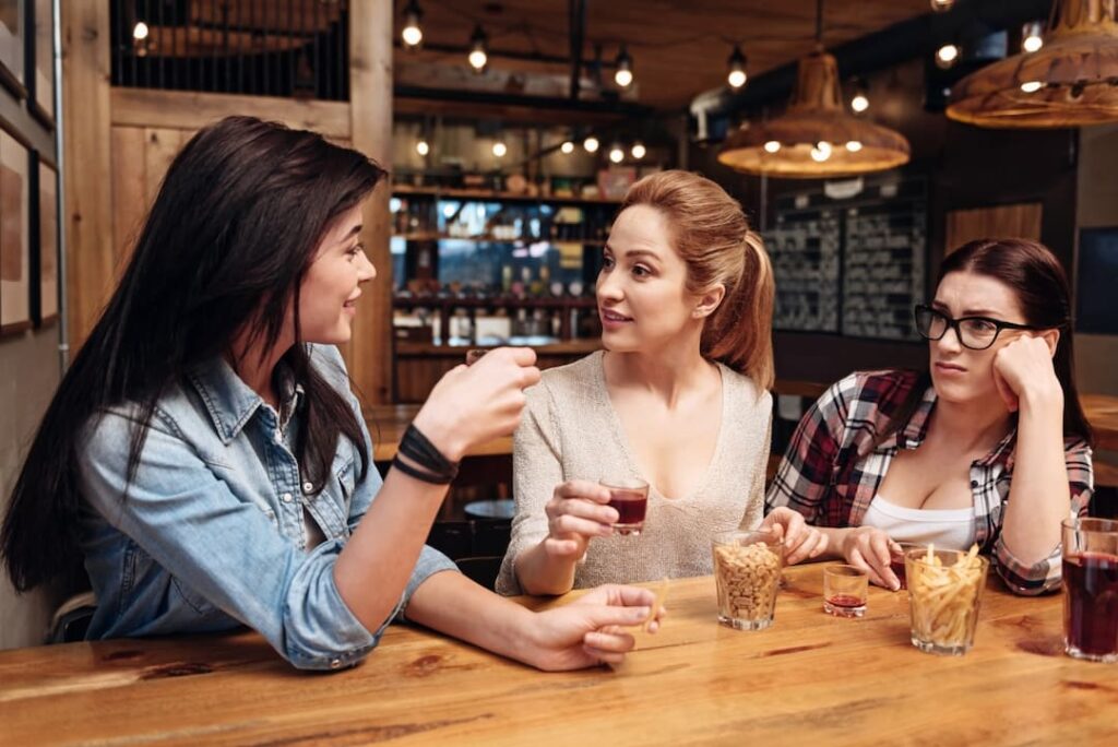 3 girls in a bar talking