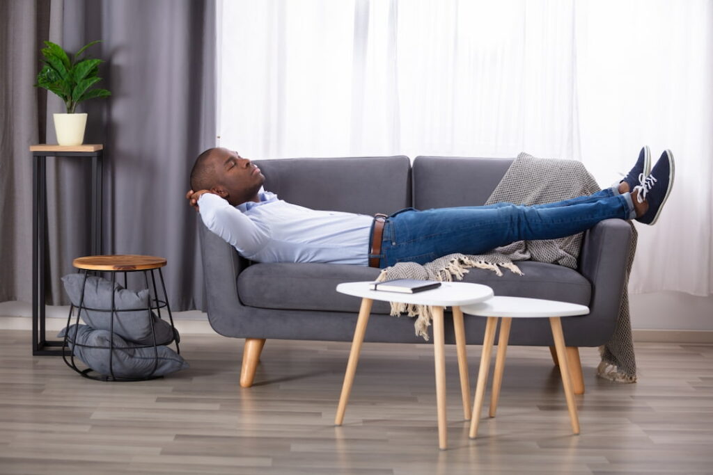 a man lying on the sofa in his living room