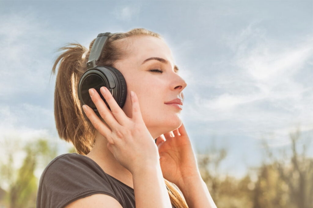a young woman with headphones listening to the audios