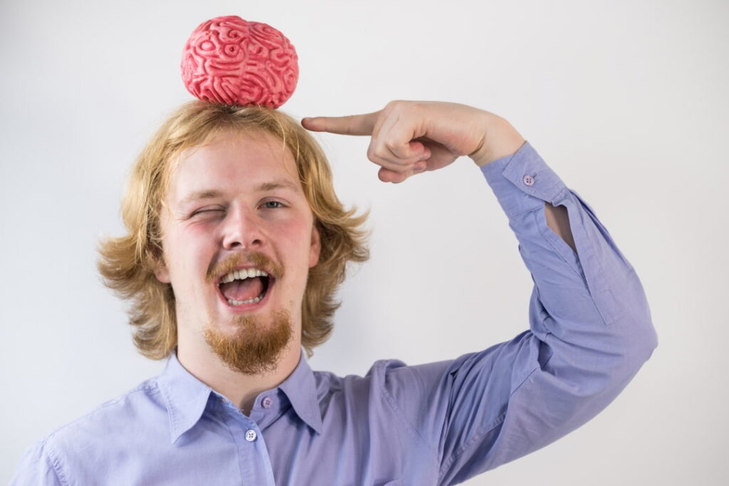 a man pointing on the brain model on his head