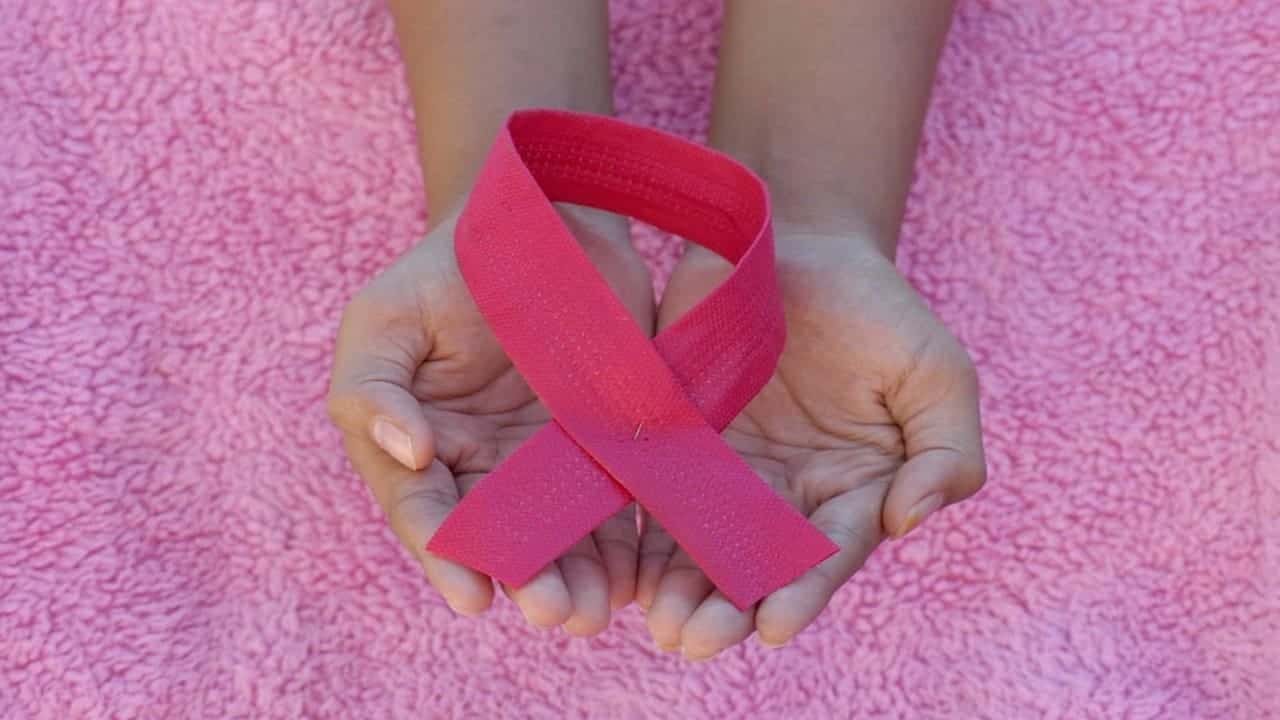 hands holding the pink ribbon