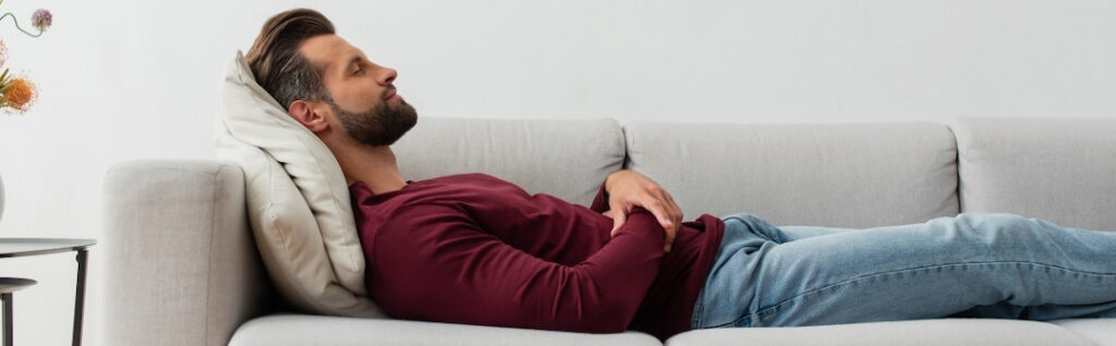 man relaxing on the couch with his eyes closed