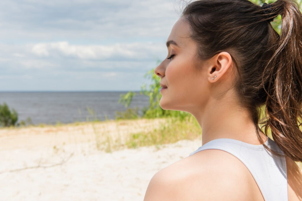 a girl with close eyes relaxing by the sea