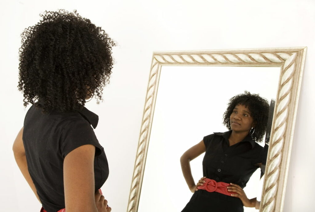 a woman looking at herself in the mirror