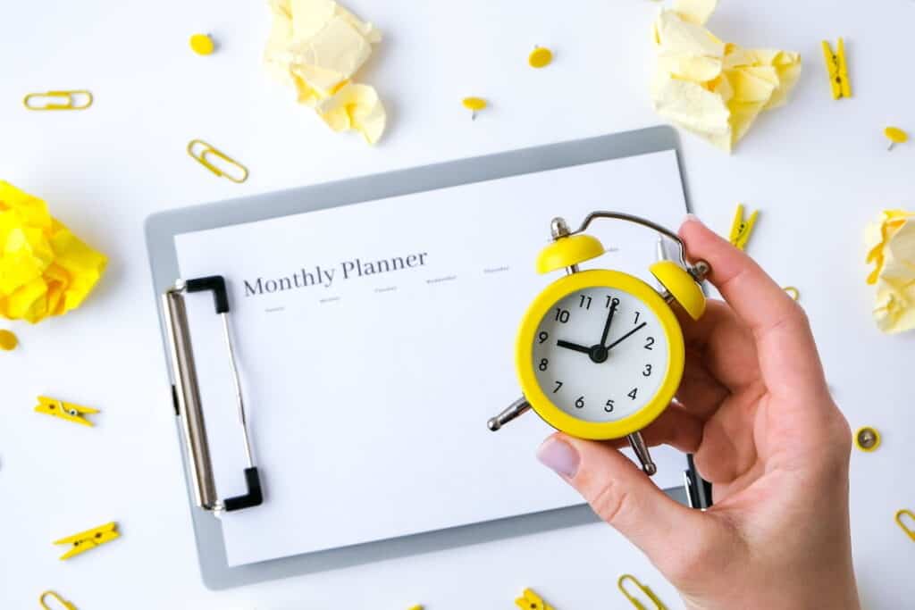 Monthly goals planner and yellow alarm clock 