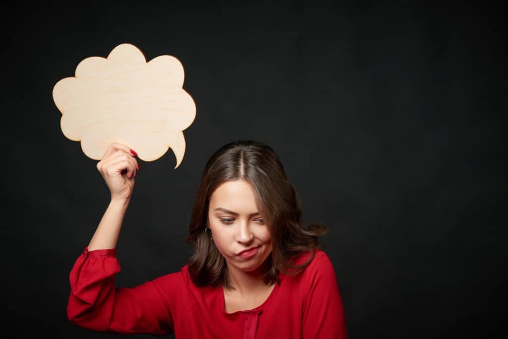 a woman holding a thinking bubble above her head 