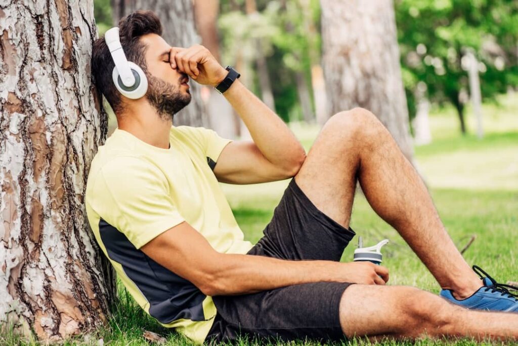 a man in sportswear listening audios with headphones