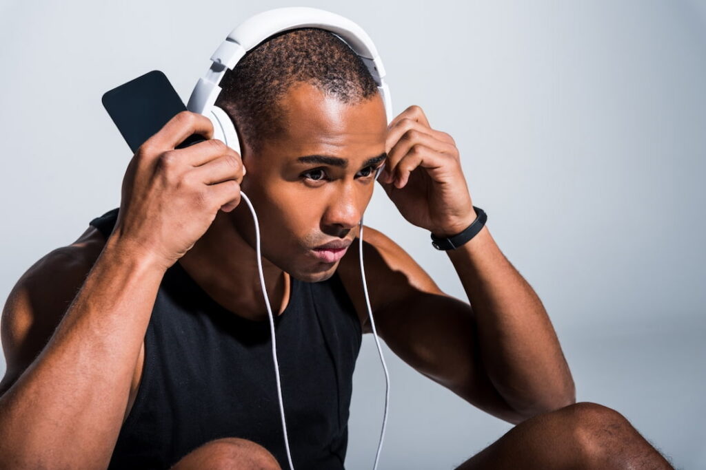 young athlete using headphones and cellphone