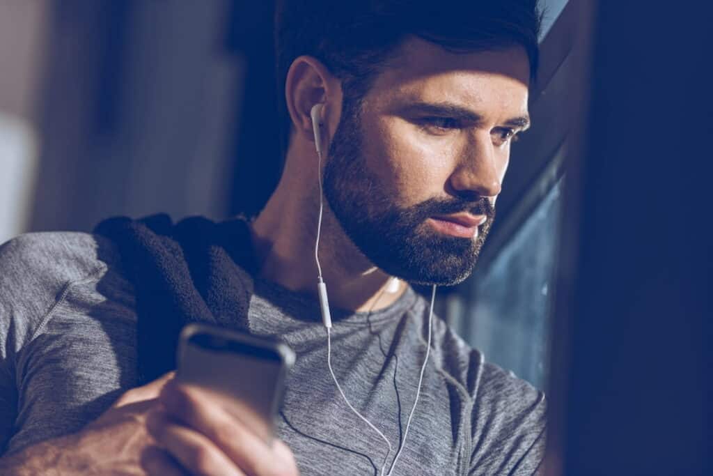 a man listening the audio downloads from his cellphone