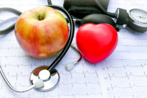 an apple, a red heart and a stethoscope