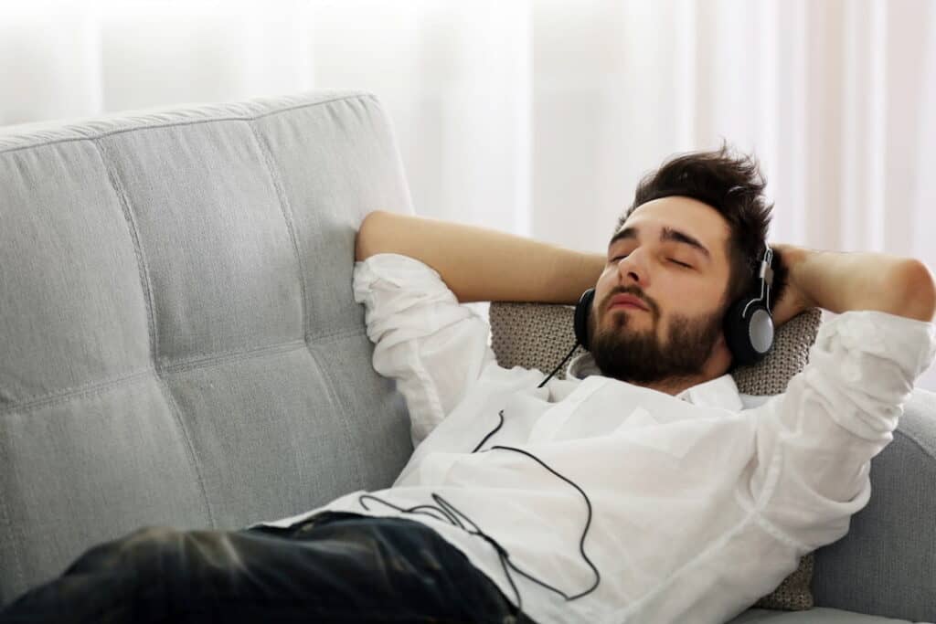 zoung man listening to the audios with headphones on his ears