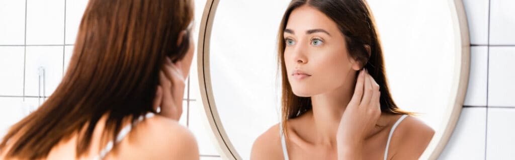 young woman looking at herself in the mirror