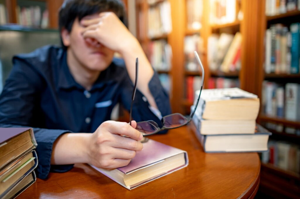 a tired student sitting in the library 