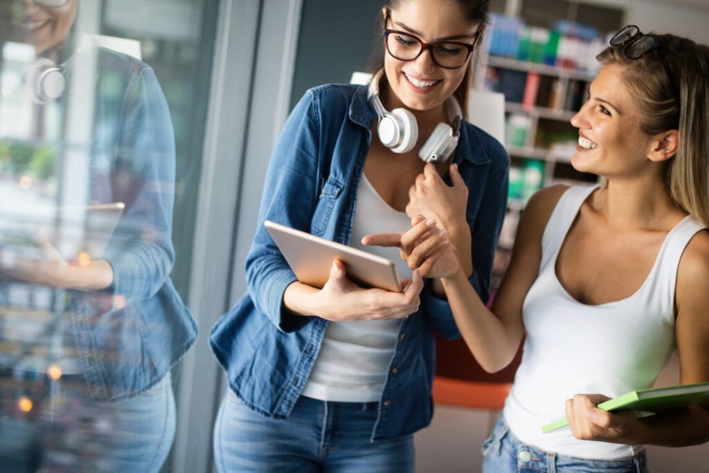 two young girls looking at the notes and smiling