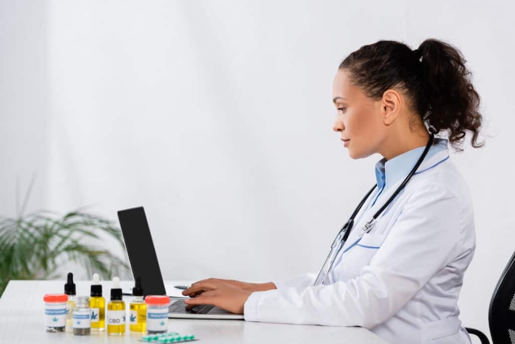 a female doctor sitting at the desk and typing