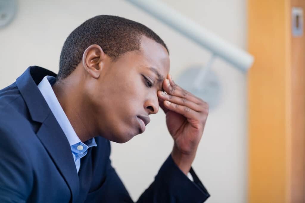 a man thinking with a hand on his forehead