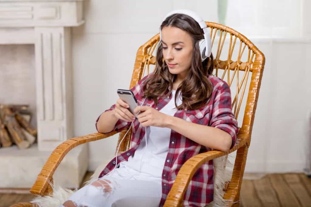 a woman listening to audios on her mobile phone