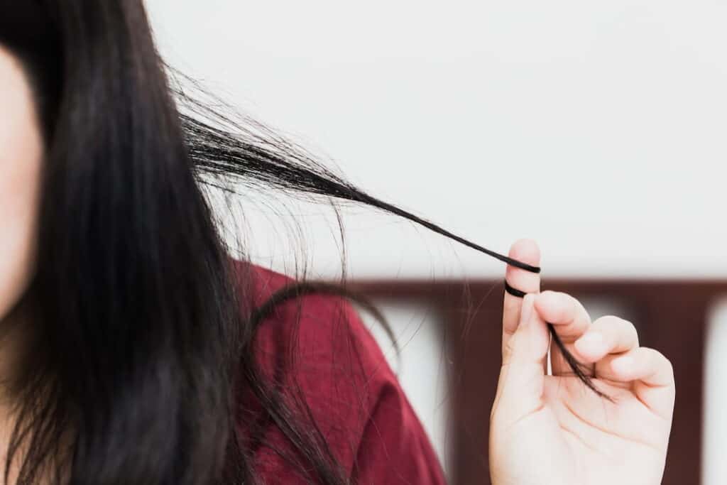 a woman pulling a lock of her hair