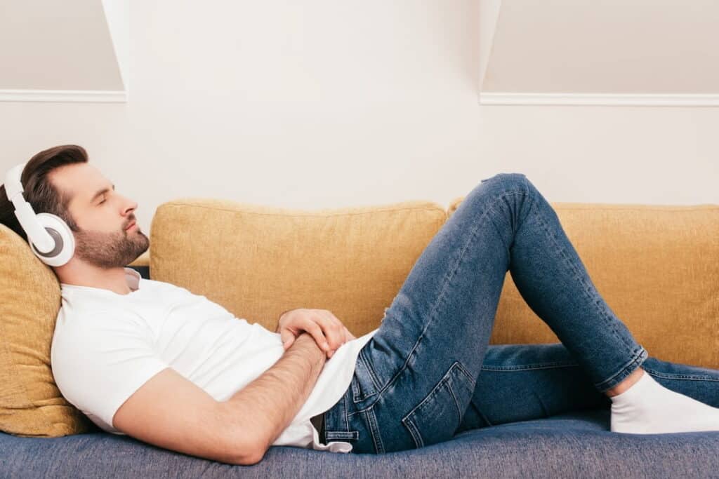 a man with headphones lying down and listening guided hypnosis