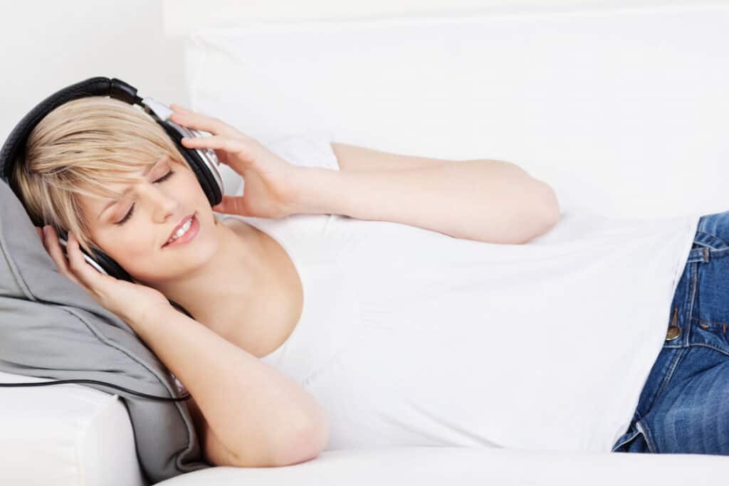 a woman with headphones listening to audio downloads