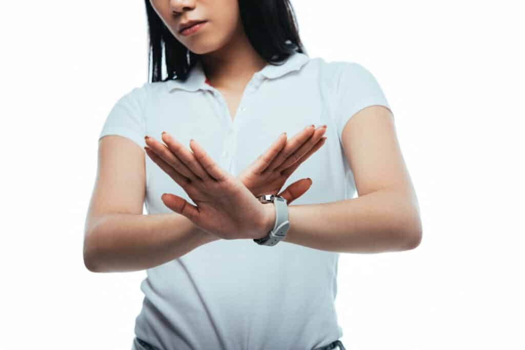 a woman in white shirt showing NO gesture with her hands