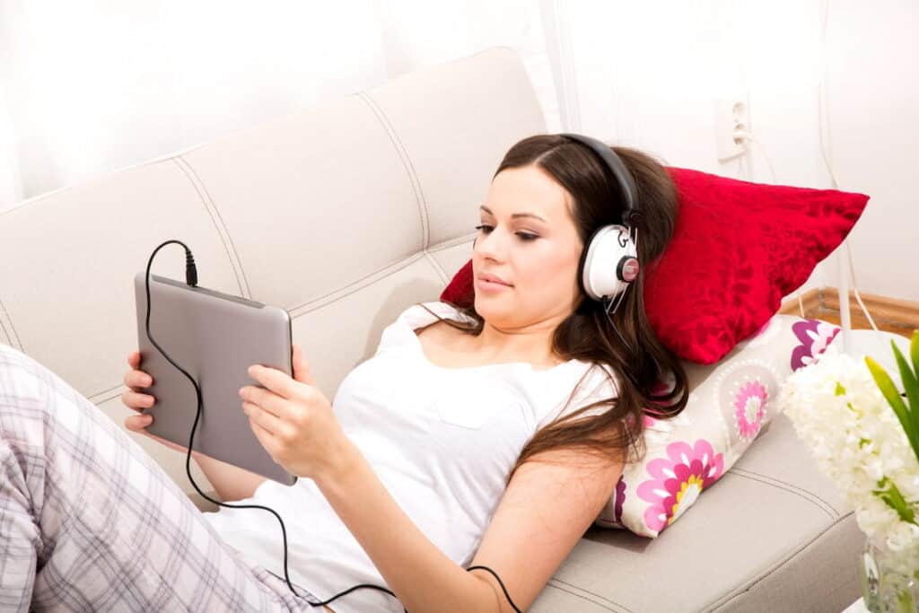 a woman listening to guided hypnosis on her notebook