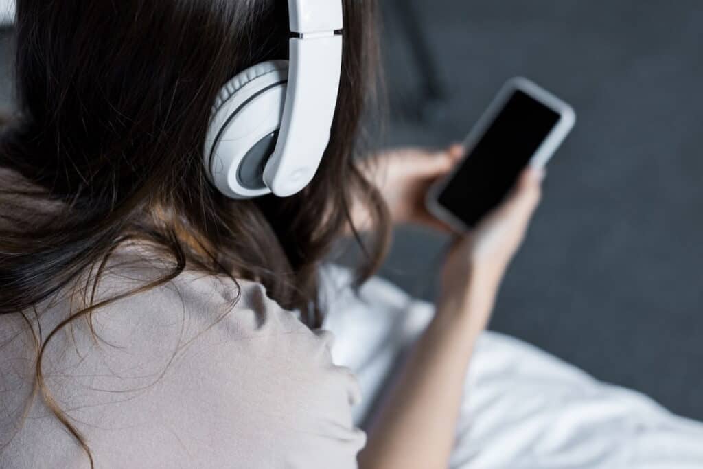 a person listening to downloads with mobile and headphones