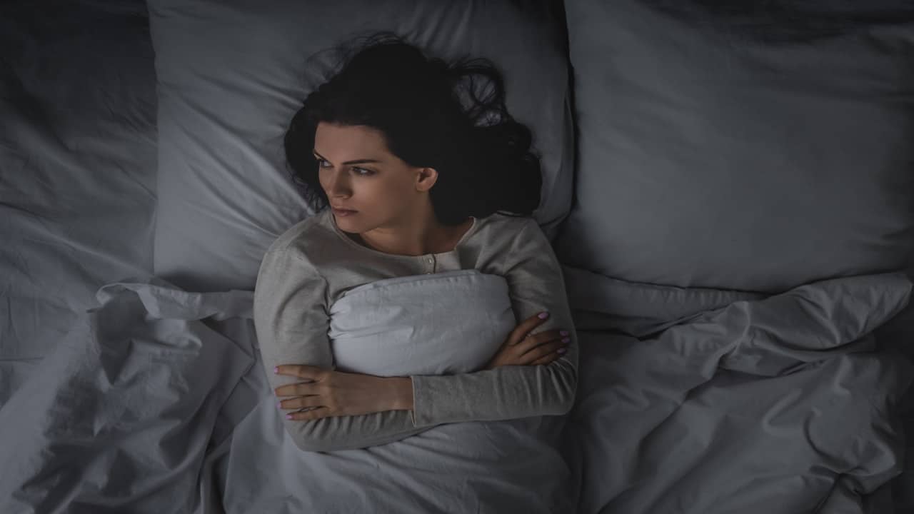 a woman with sleep disorder lying in the bed