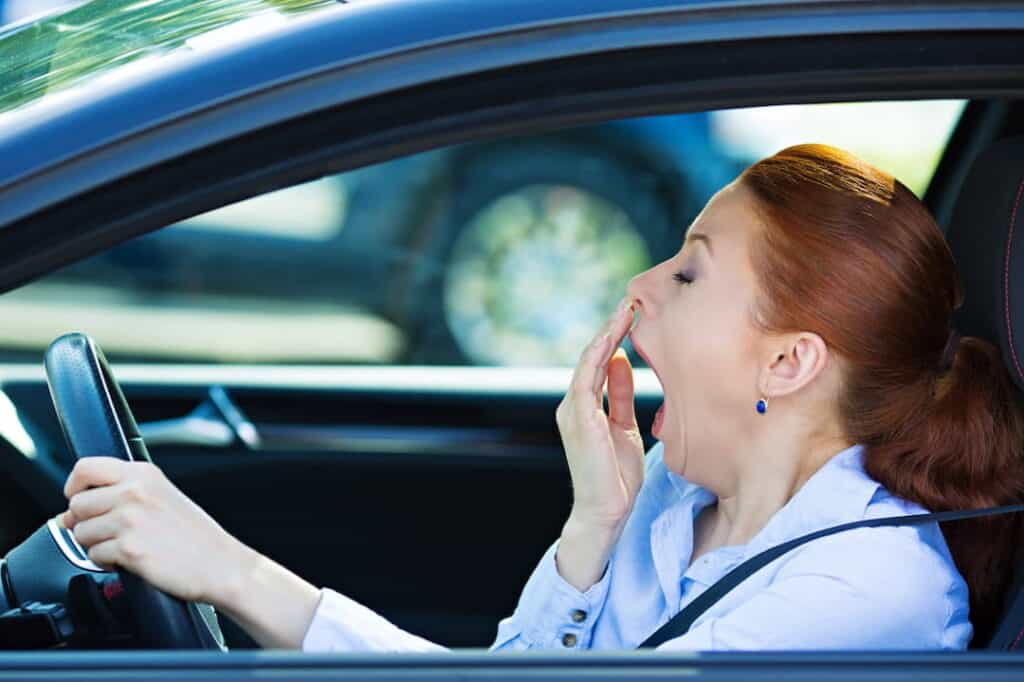 fatigued woman driving a car