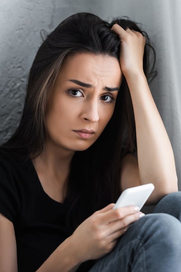 a frustrated woman with mobile phone in her hand