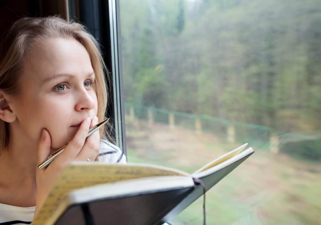 a girl thinking with a notebook and pen in her hands
