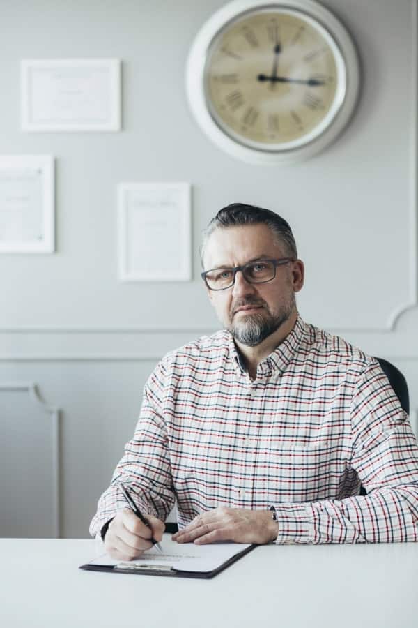 a hypnotherapist sitting at the desk in his office