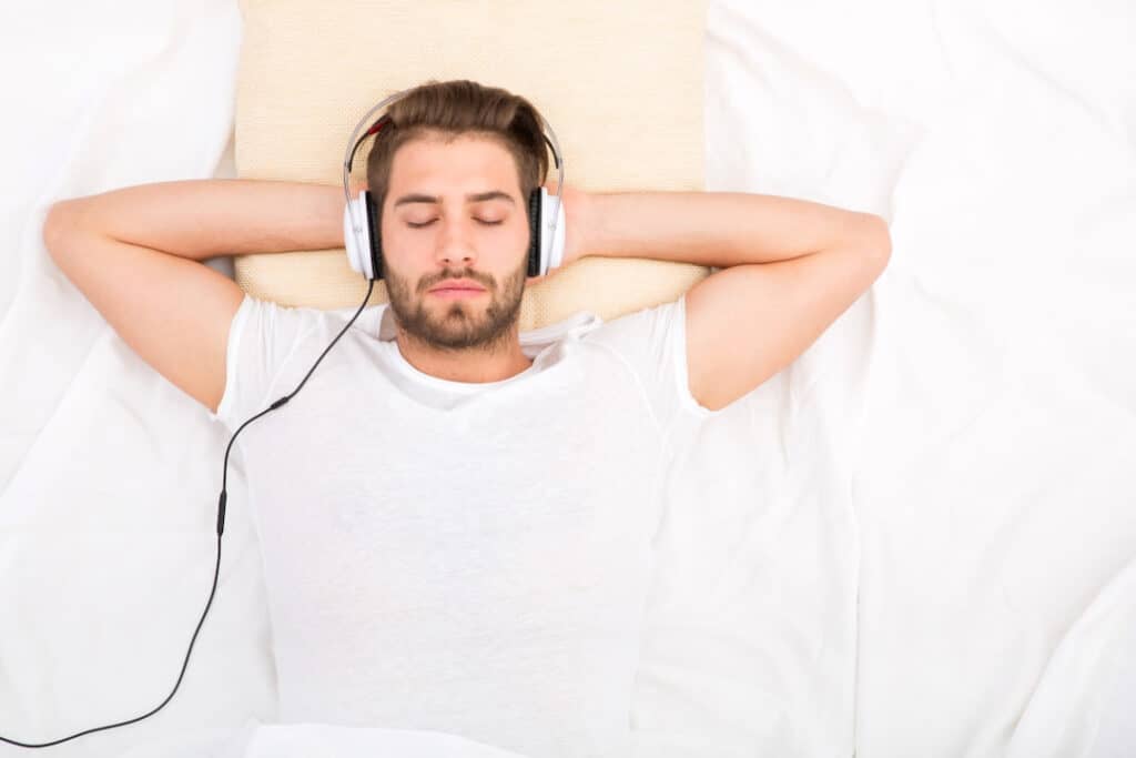 a young man relaxing with headphones on his ears