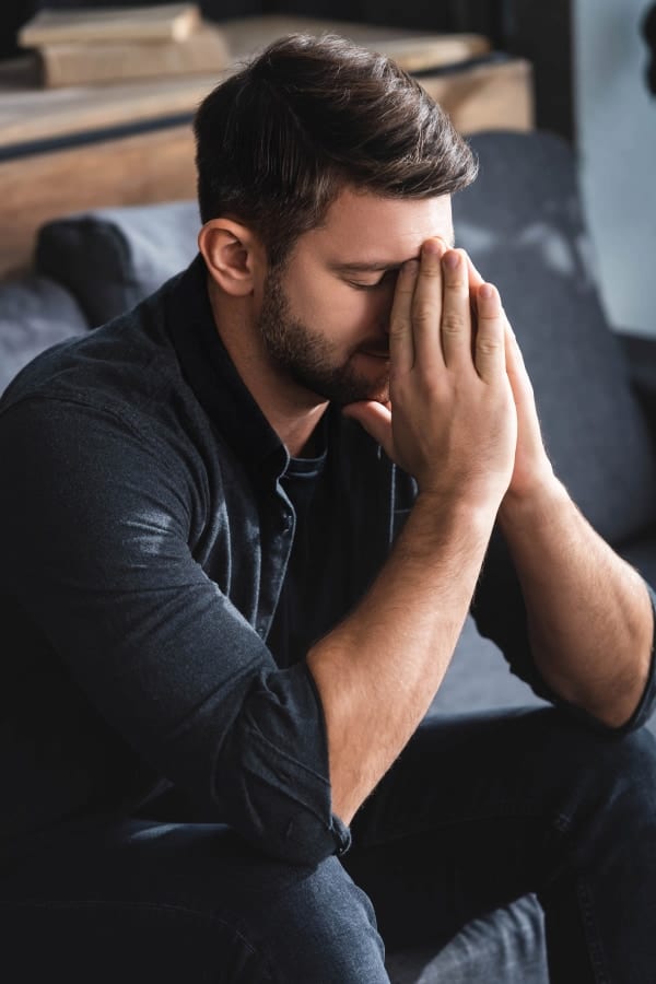 a young man with closed eyes feeling stressed