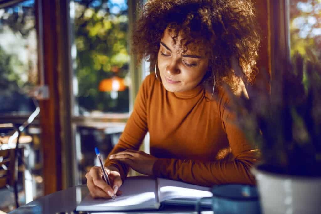 a woman sitting at the table  and writing