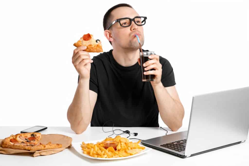 a man eating in front of the computer