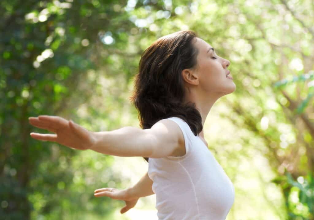 a woman meditating outdoors 