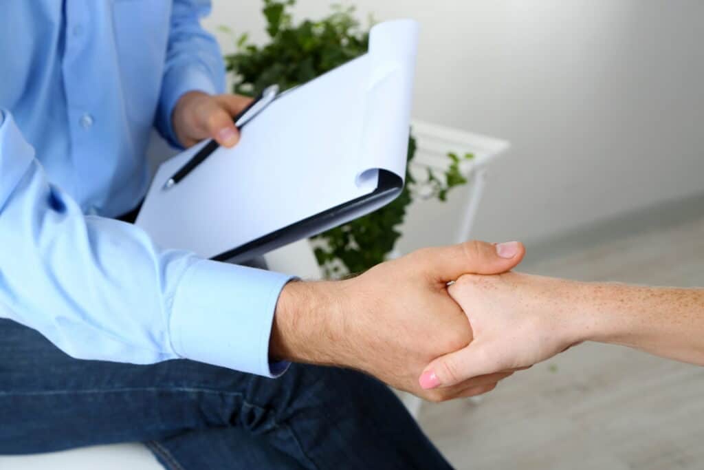 a therapist and a patient shaking hands