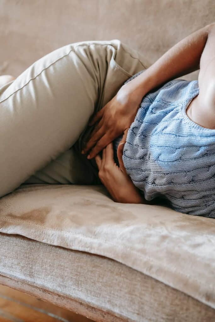 a person in pain lying down on the bed 