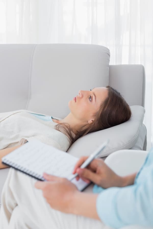 a woman lying on the couch during the hypnosis session