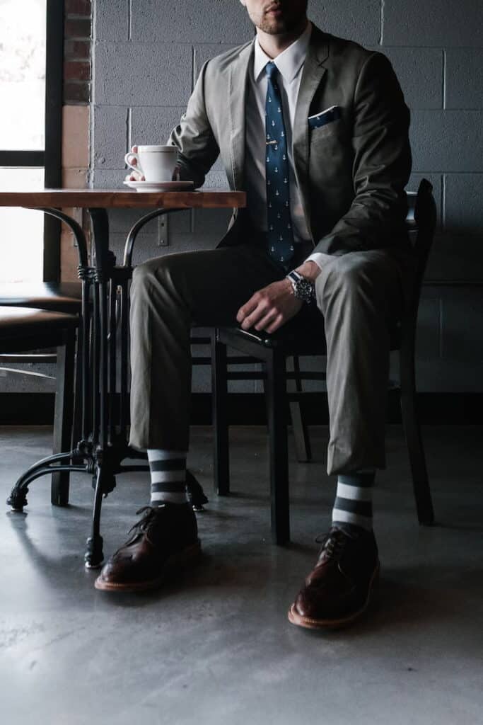 a man in the suit sitting alone in the bar