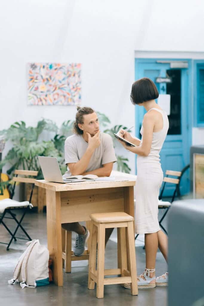 two people discussing and taking notes